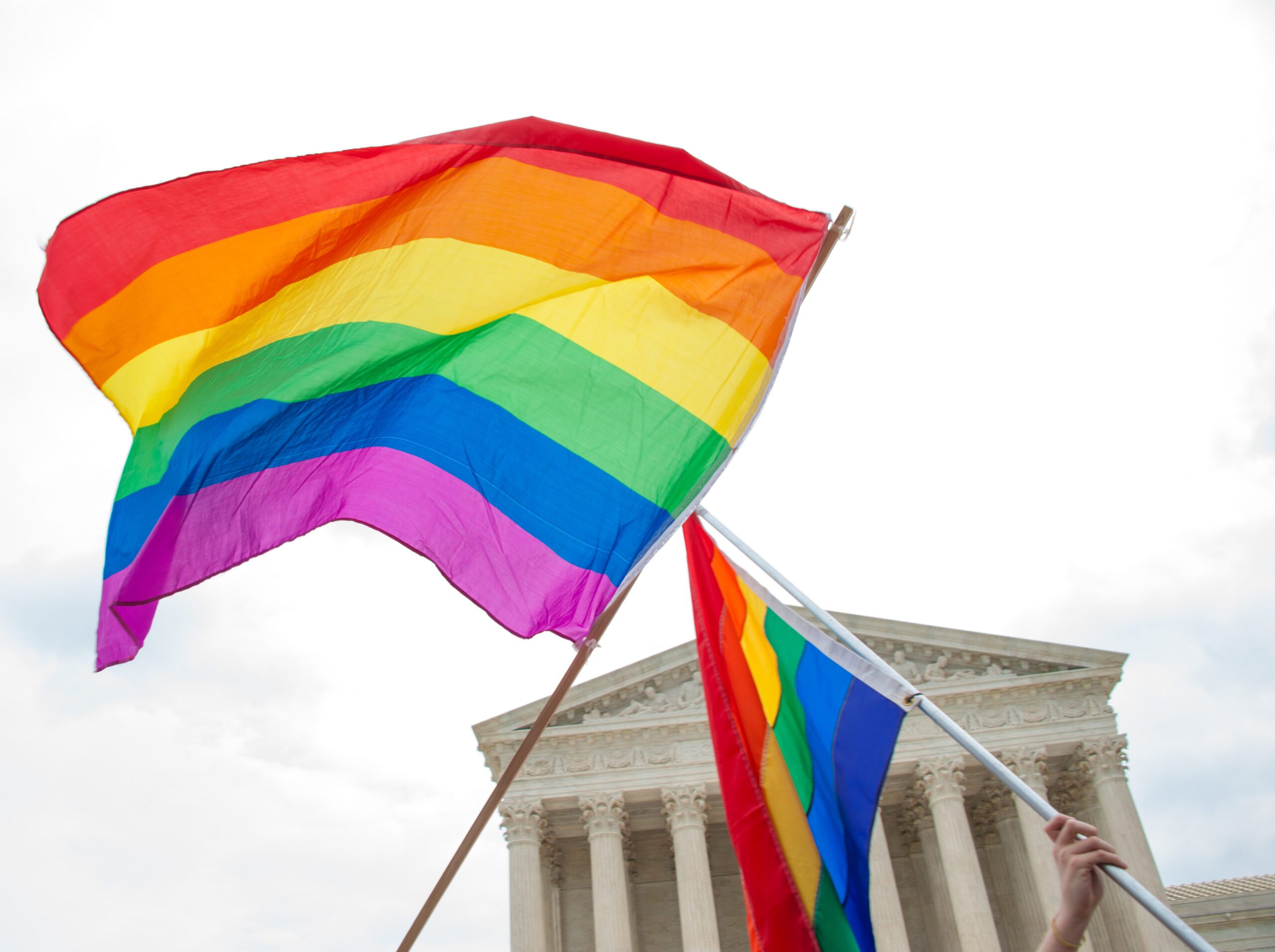 Two pride flags waving in front of the Supreme Court