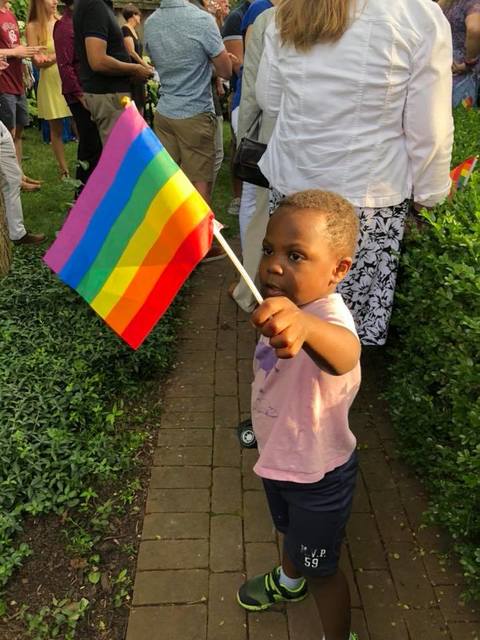 young black child waving a pride flag
