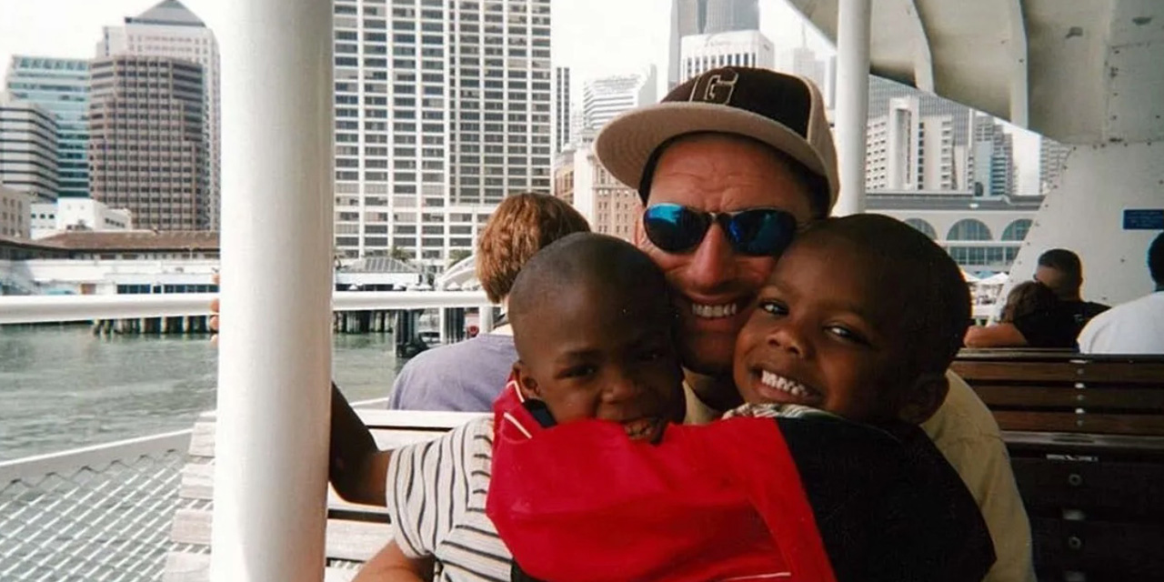 Photo of a white father with his two African American children on a ferry