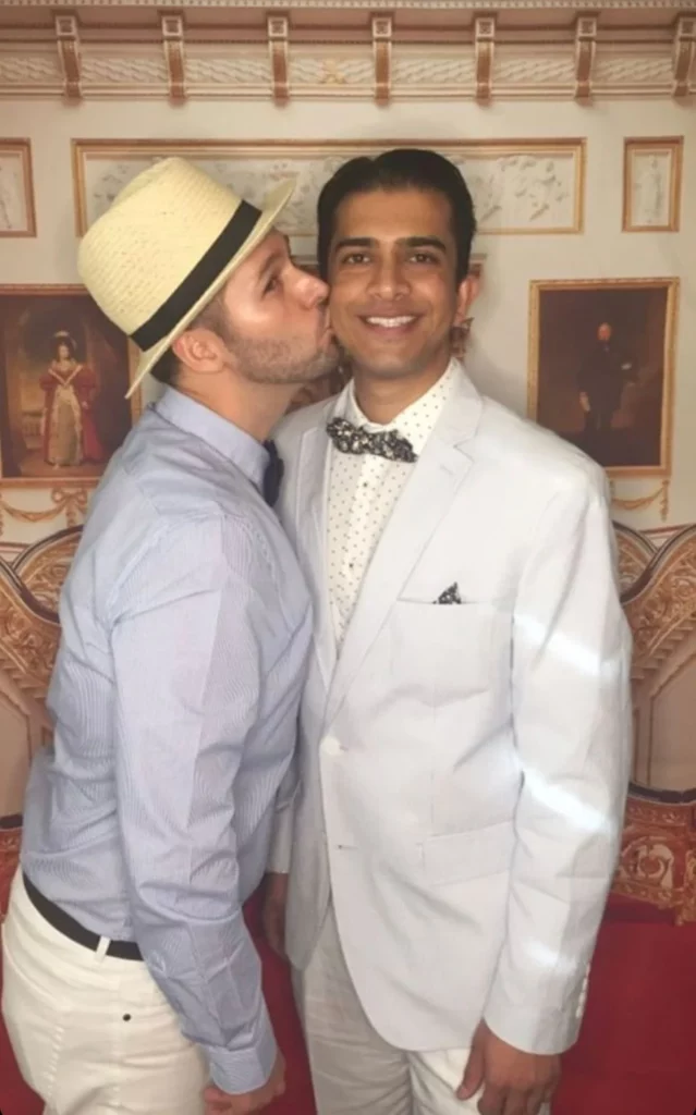 couple in bow ties one kissing the other on the cheek