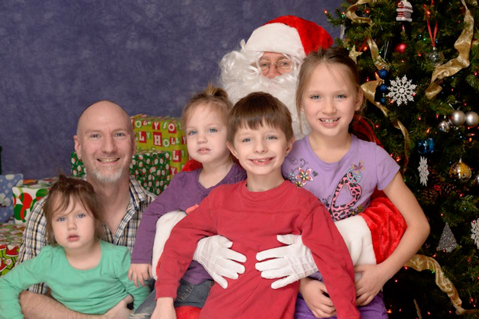 Father and four children posing with Santa