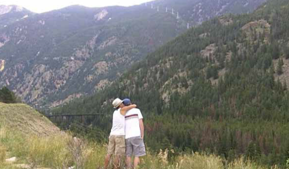 Gay couple looking out over a mountain range