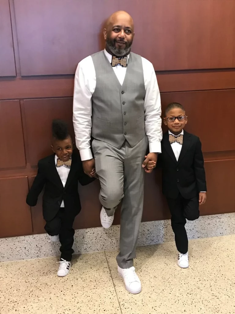Dad with his two sons on adoption day wearing matching bow ties made of scrabble letters