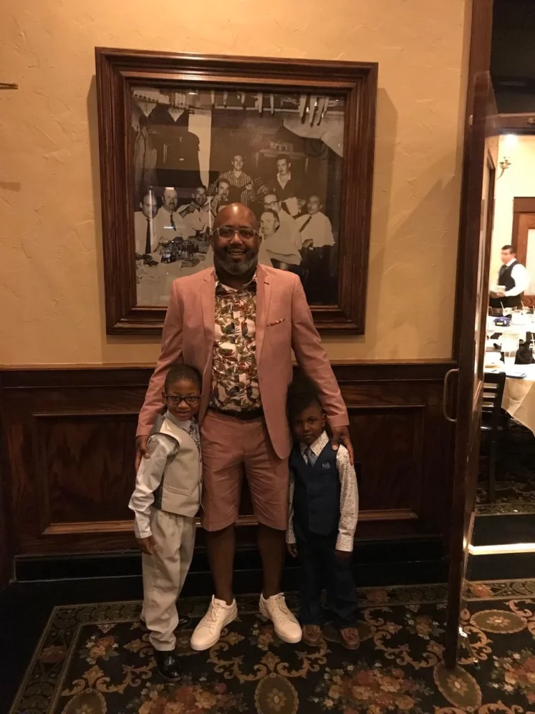 Father and sons dressed up in blazers and vests at a restaurant