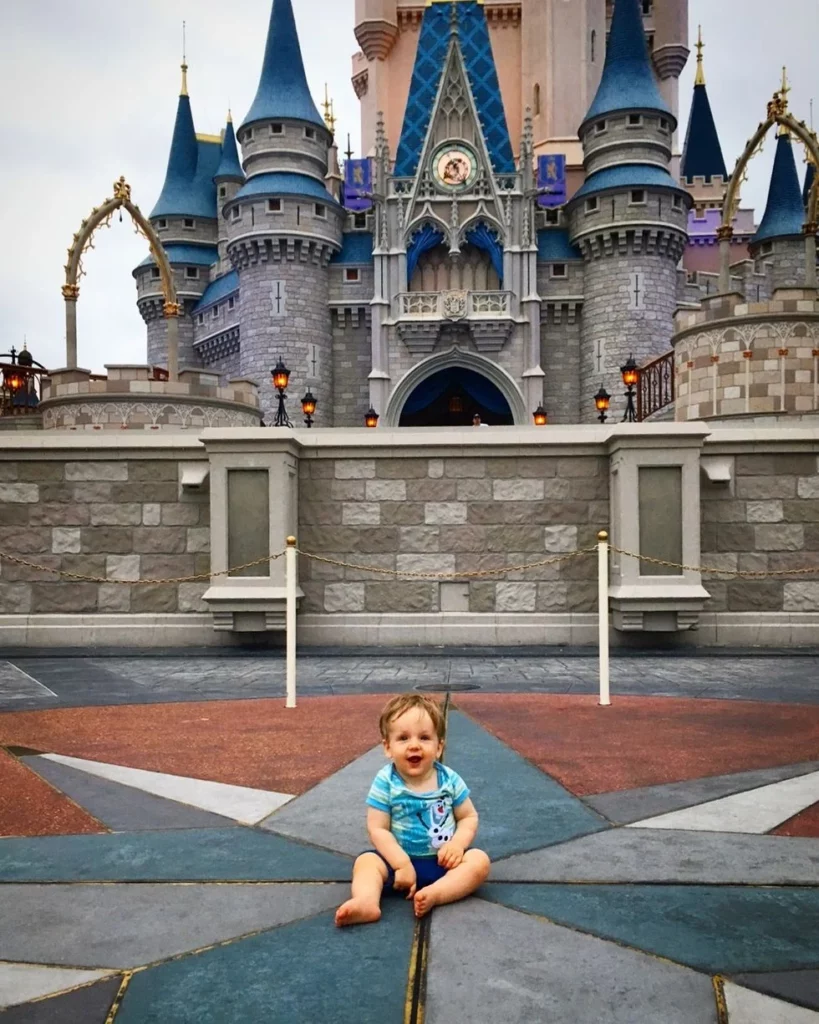 Toddler sitting in front of Cinderella's Castle at Disney