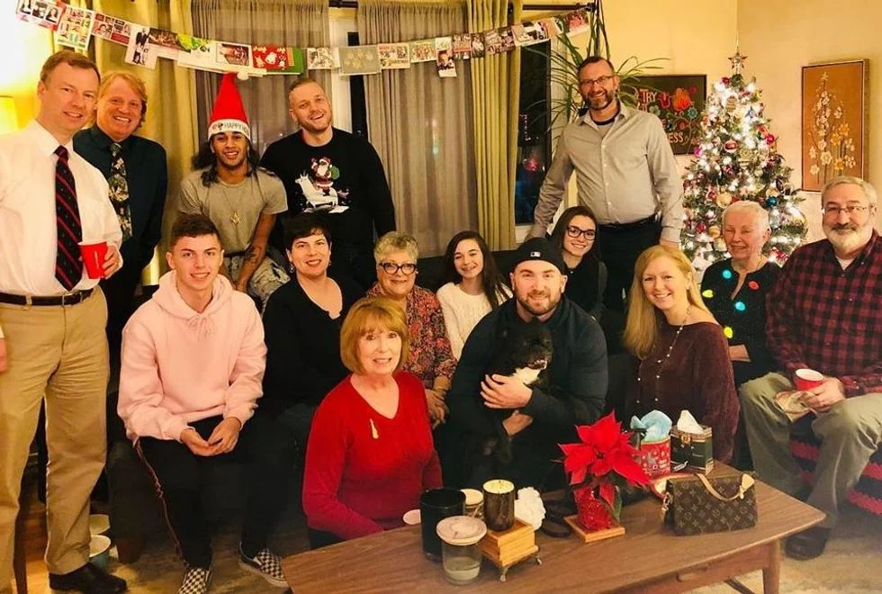 large family in living room posing in front of christmas tree