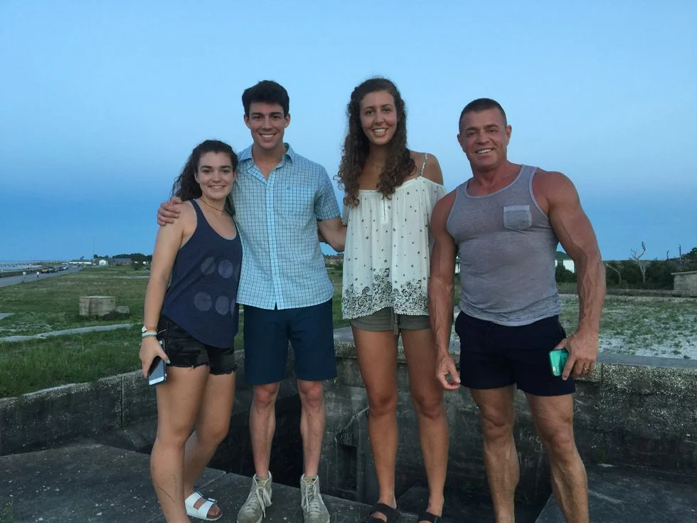 Photo taken during the summer at dusk with man and two teenage boys and a girl
