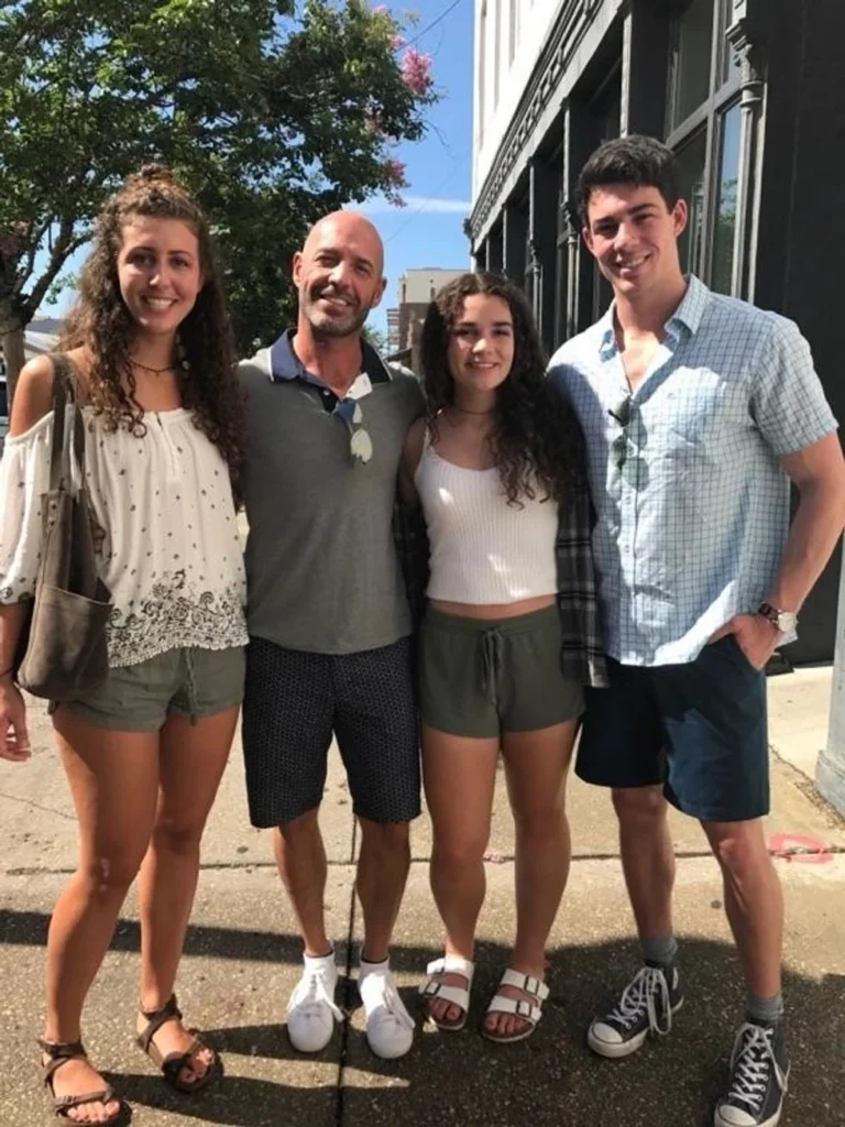 Father posing on the street with his two daughters and son