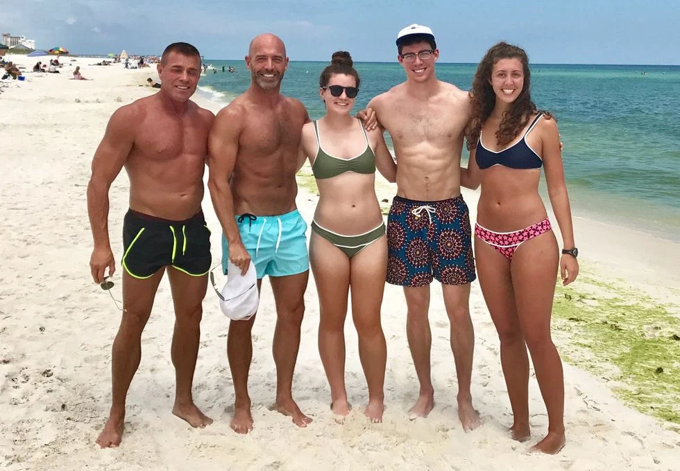 Father on the beach with his two daughters, son and his new husband