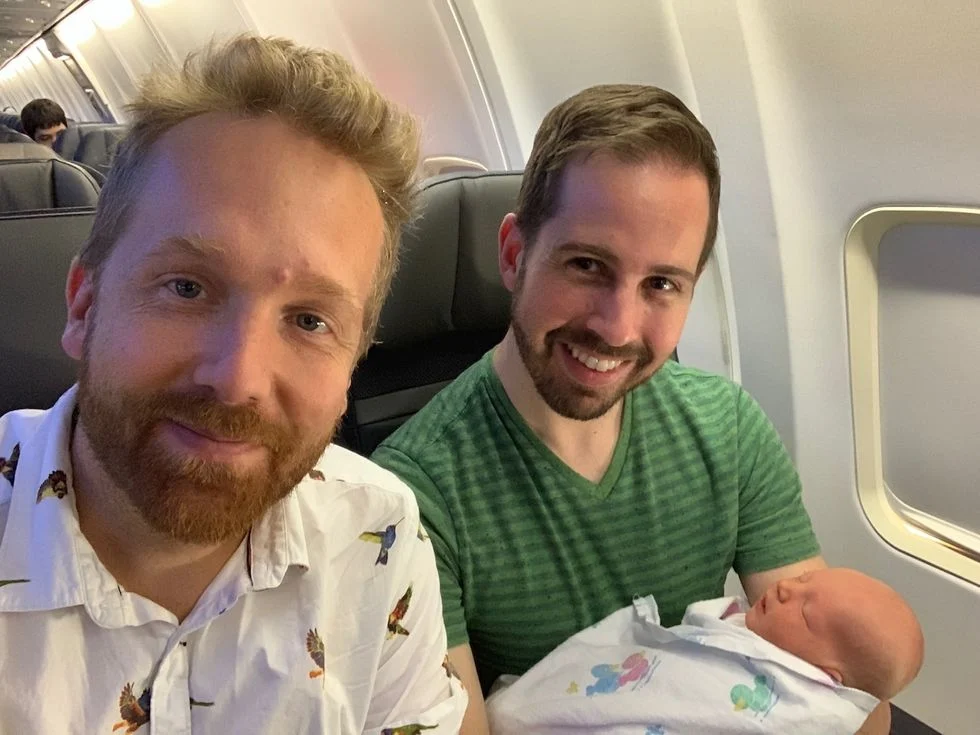 A couple flying on a plane with their newborn