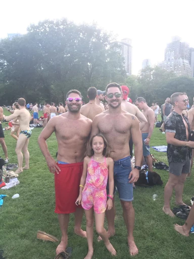 Two dads and thier daugher in bathing suits in Central Park