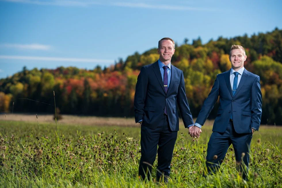 Gay couple holding hands in a field