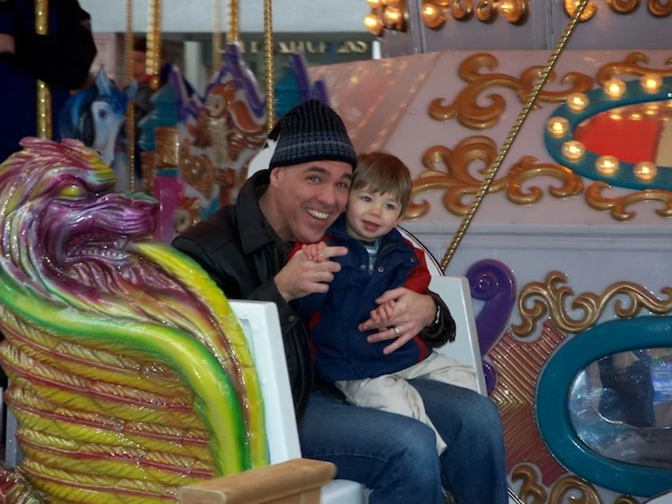 Father and son on merry go round