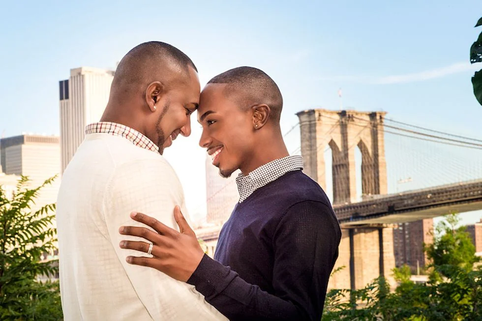 Gay couple posing in front of bridge