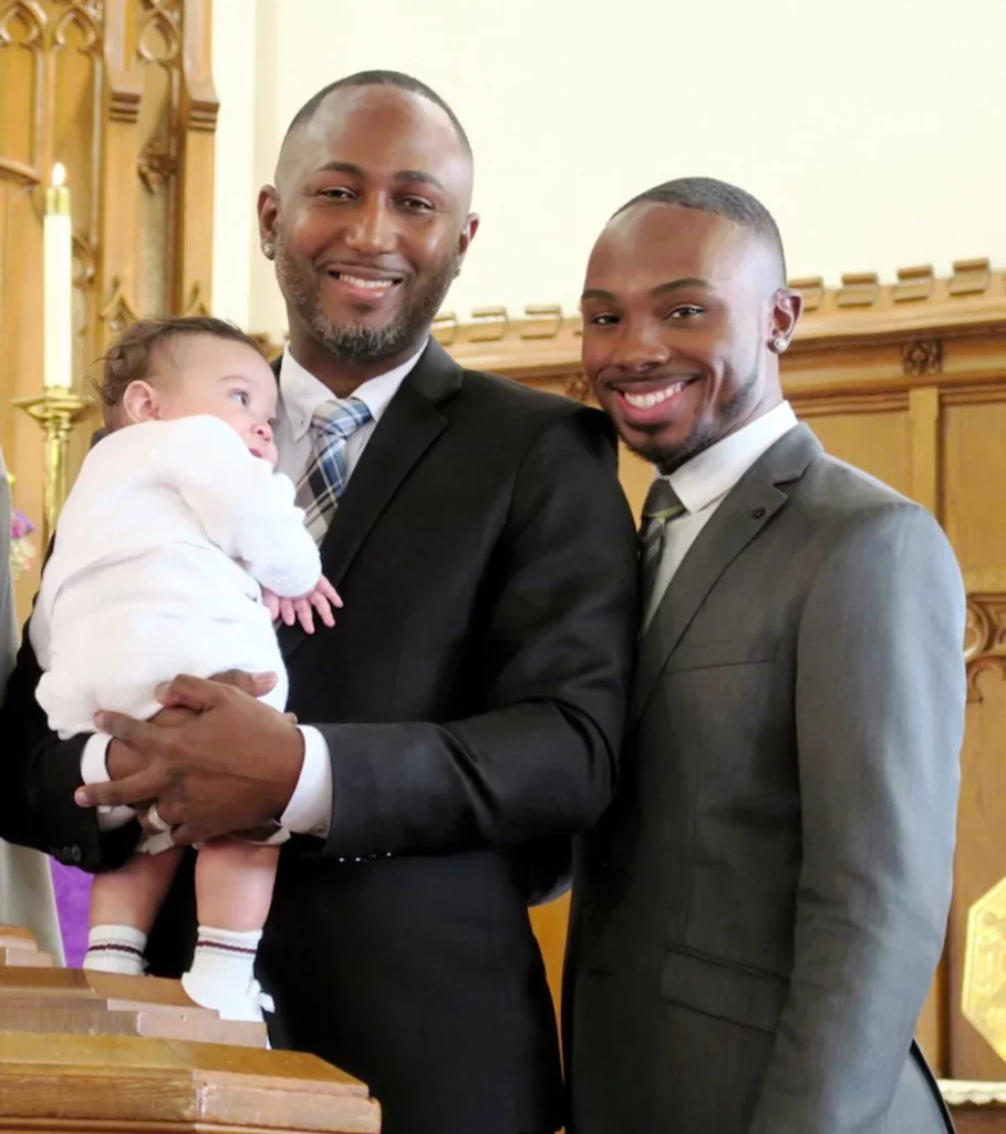 Gay couple posting with newborn at church