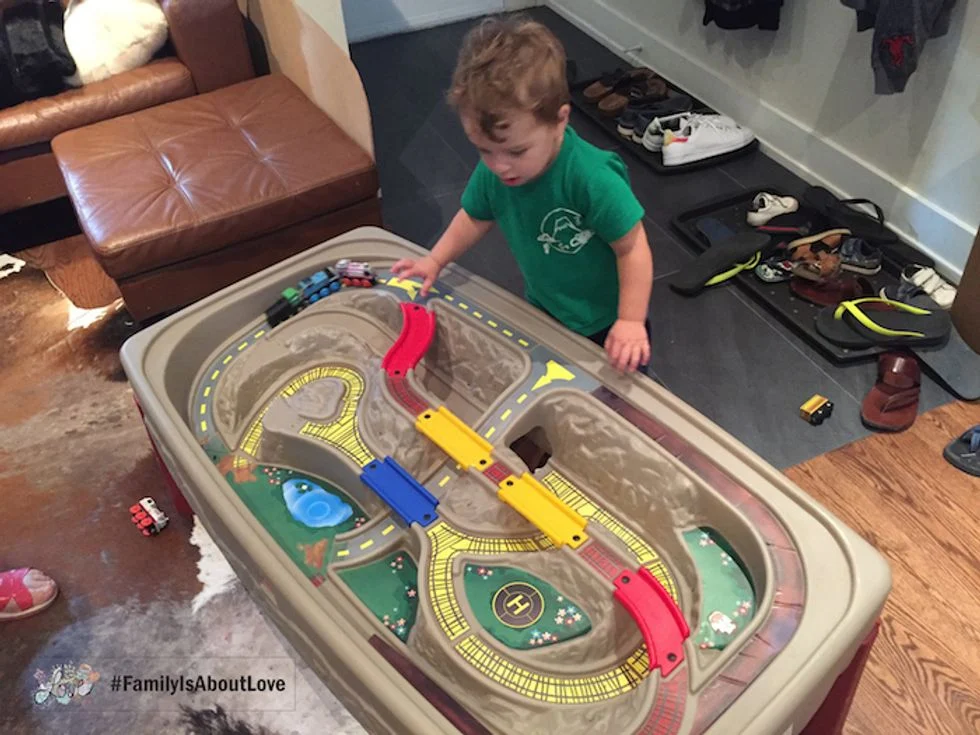 Toddler boy playing with his train table