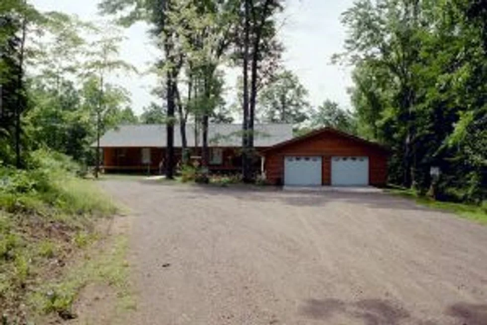 A home surrounded by trees with a long driveway