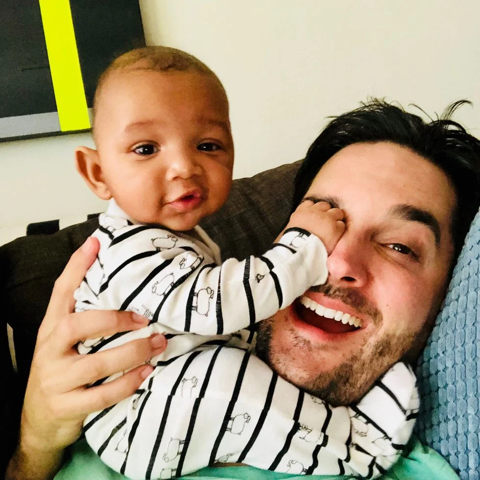 Foster dad with baby boy grabbing foster dad's face