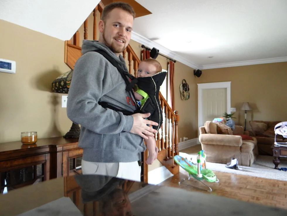 Dad holding baby in front carrier