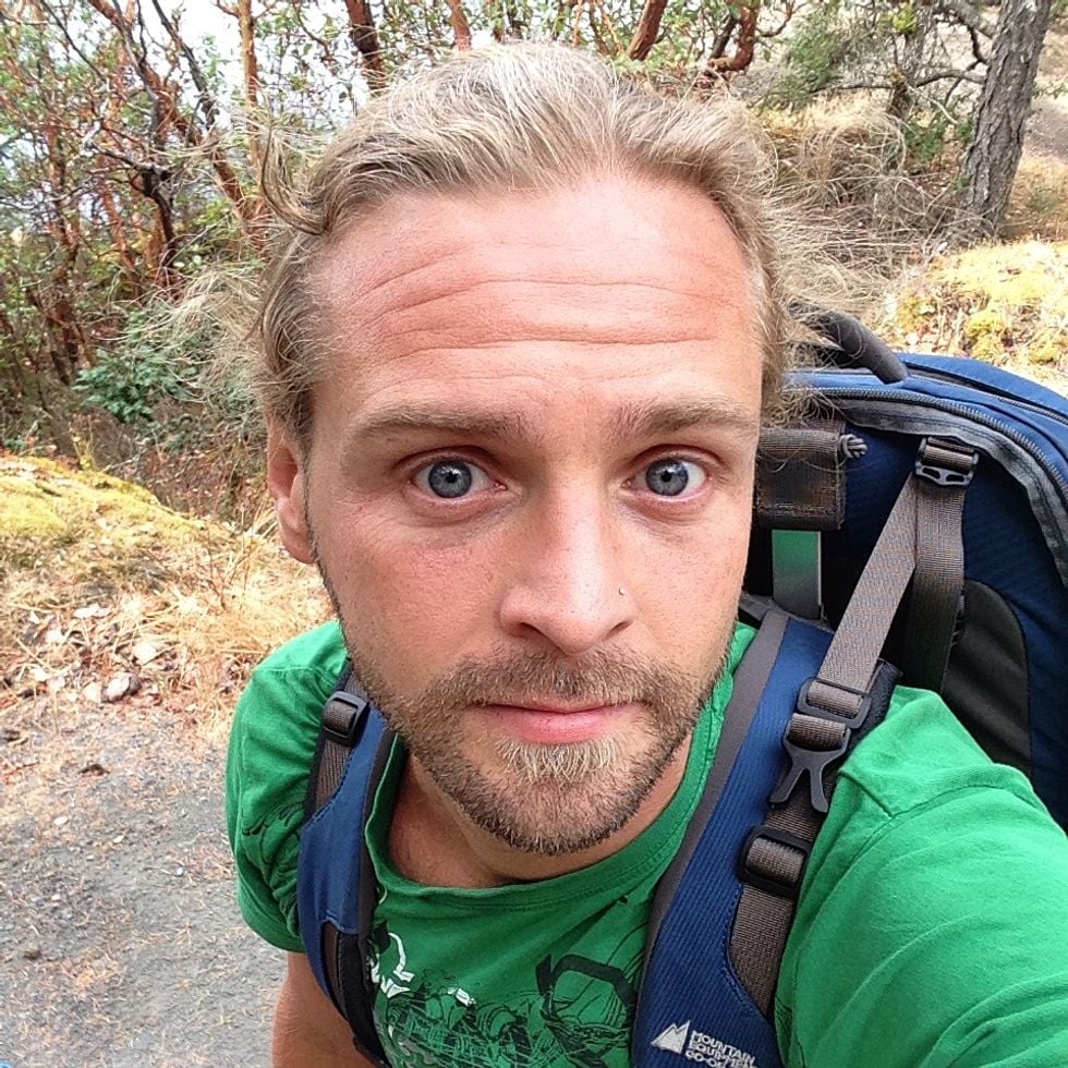 Selfie of dad wearing backpack while hiking