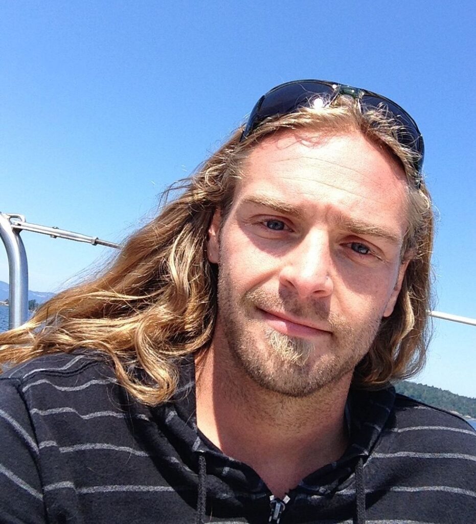 Blonde man with long hair on boat