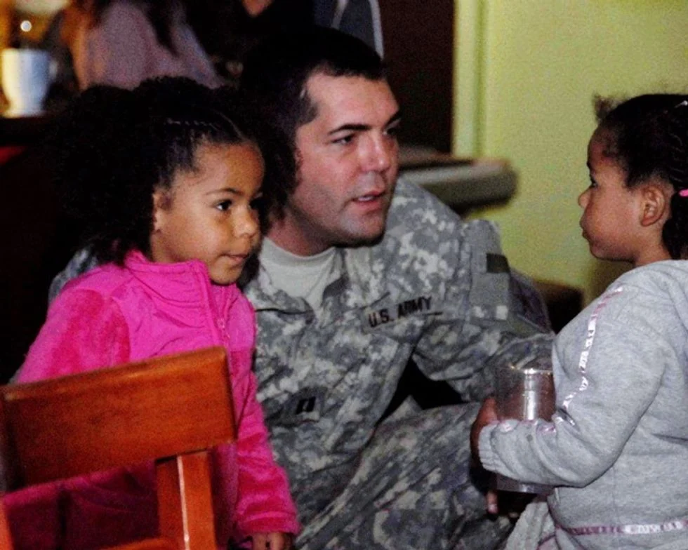 Gay dad in army uniform with his two daughters.