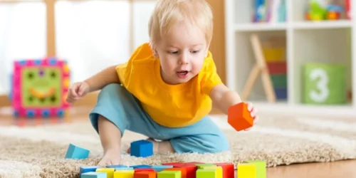 Toddler playing with blocks in a play room