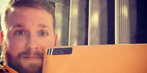 Man at post office holding adoption paperwork