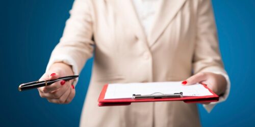 Person holding clipboard and pen