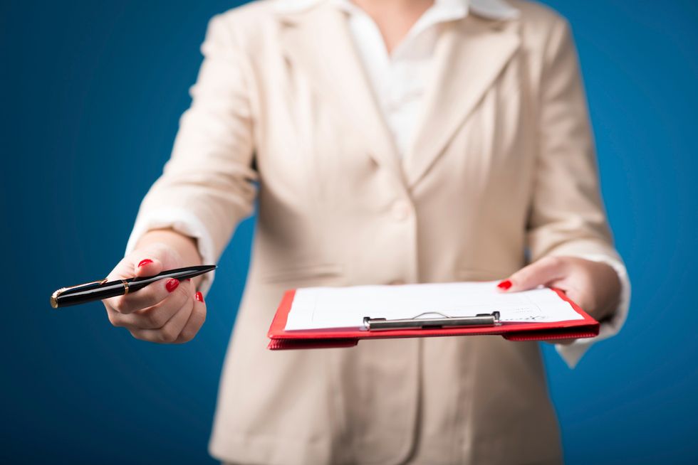 Person holding clipboard and pen
