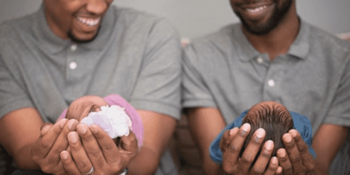 Black couple holding their newborn twins