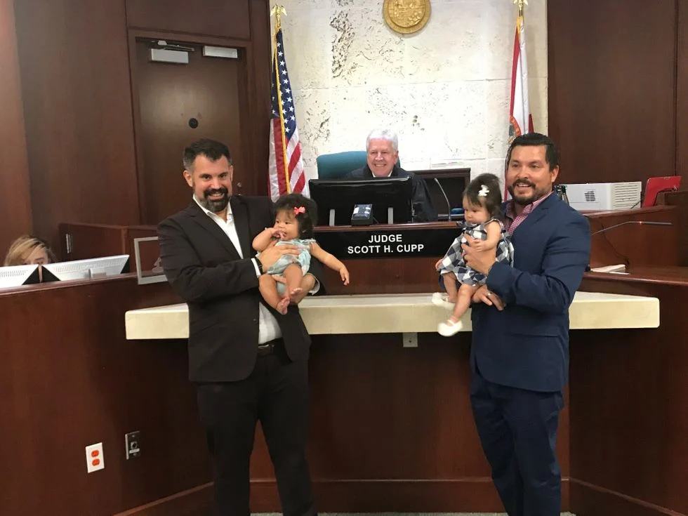 father with their two daughters on adoption day with judge