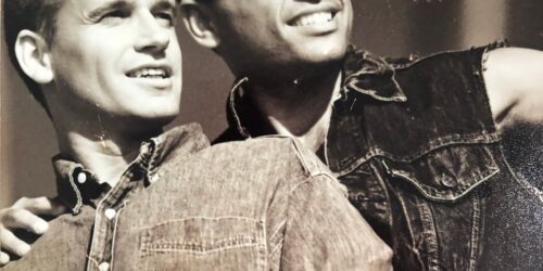 Black and white photo of two gay men posing together in denim shirts