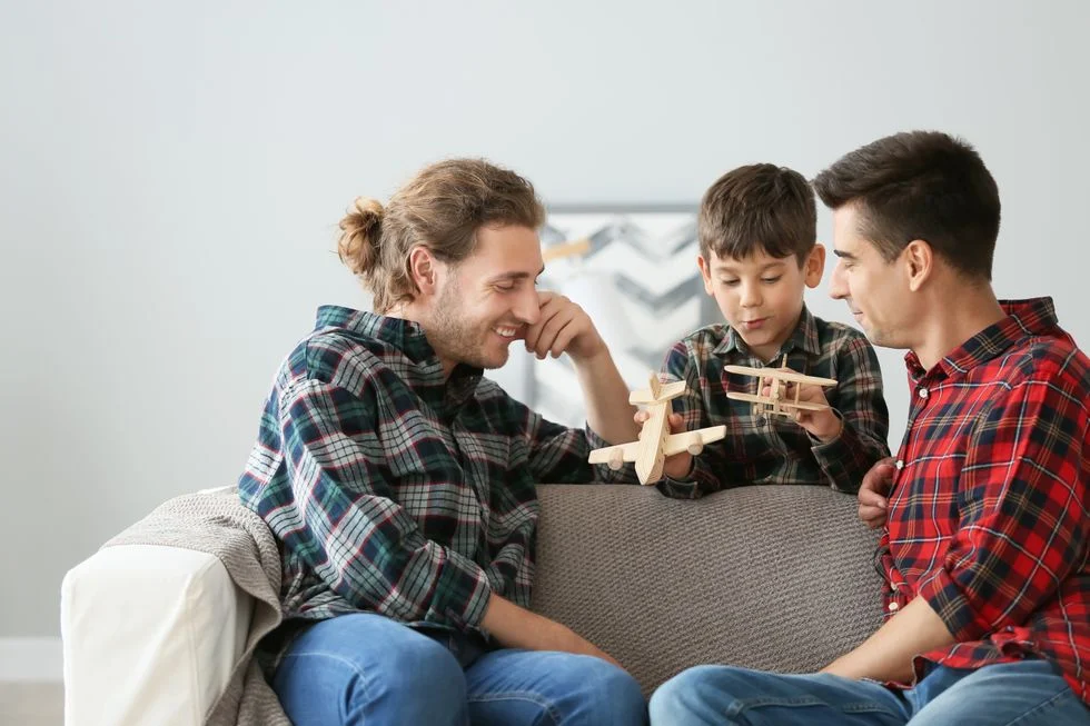 Two dad playing with their son and model airplanes
