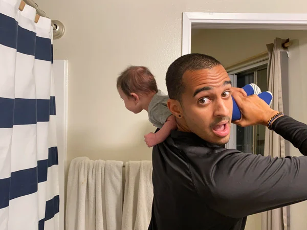 Man holding his baby on his shoulder