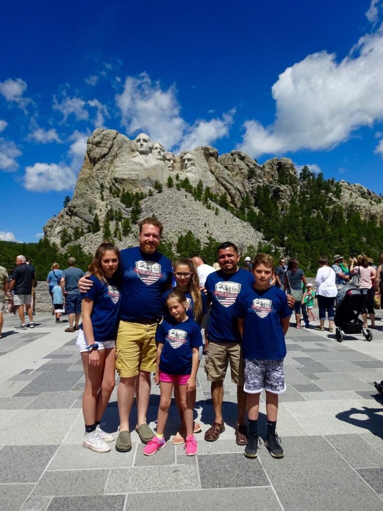 Gay dads with their four kids in front of Mount Rushmore